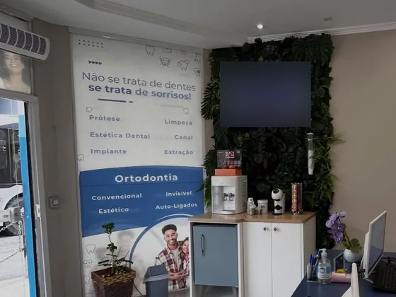 Recepção da clínica, com painel de tratamentos e jardim vertical